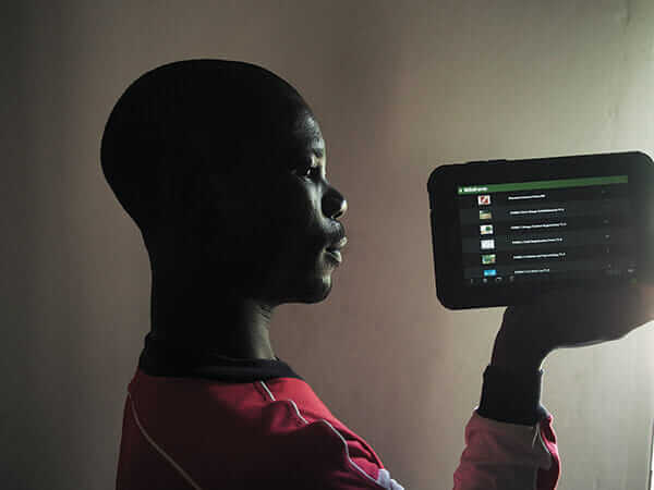 Hendrix, a Malawi Mangoes employee holds a tablet used as a registration tool for horticulturists visiting small farmers.