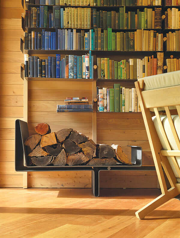 A bookshelf over a stack of firewood.