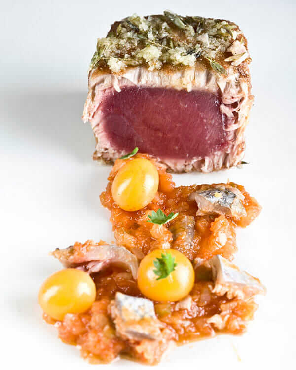 ChicharrÁ³n de atÁºn, sobre una fritada de tomates y pellejito (Crackling tuna with fried tomatoes and tuna skin).