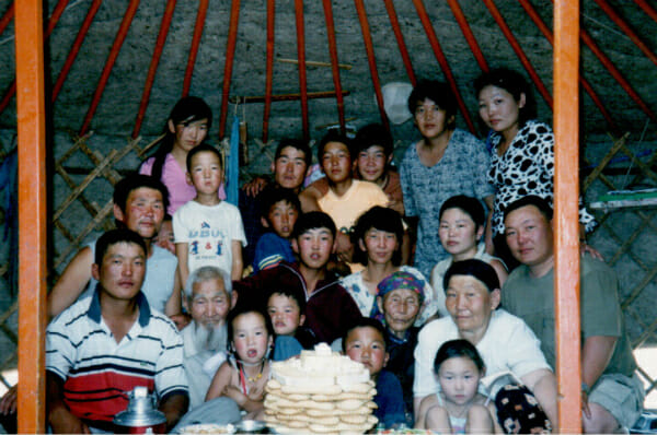 Badamsuren's uitgebreide familie in een emger/em. Hij staat helemaal links, in een grijs overhemd.