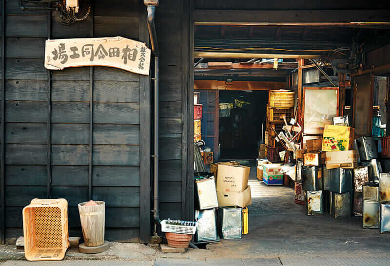 The factory's entrance. The wooden sign bears the company name, Aida Godo Kojo.