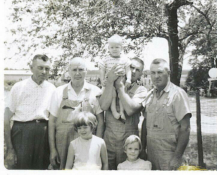 The late McKale in his overalls with family on their Kansas farm.