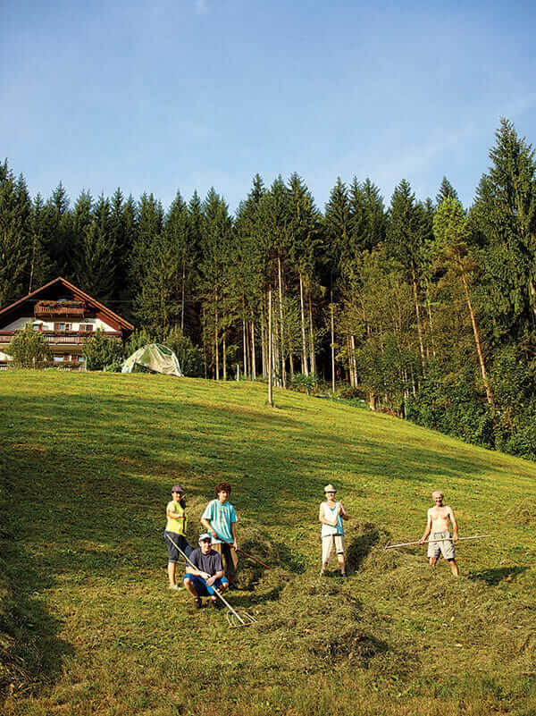 A family gathers grass clippings to make hay near the small town of Idrija.