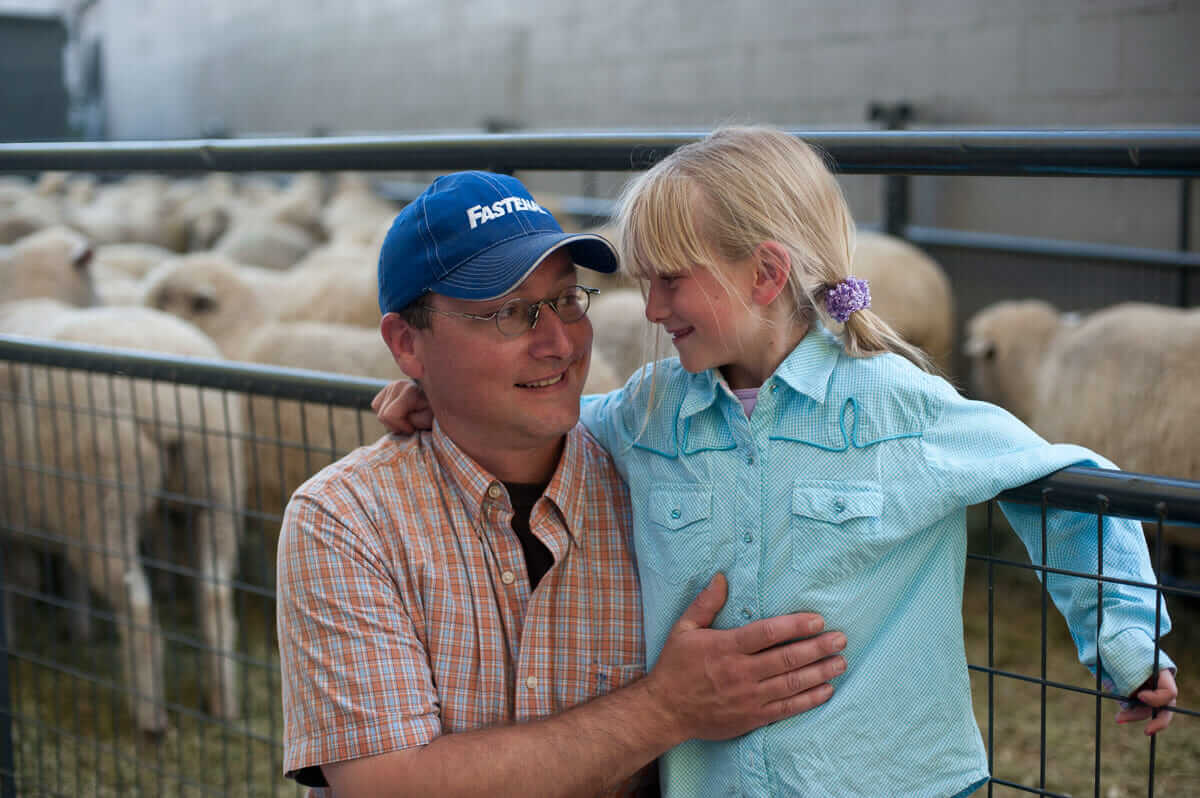 Zoe and her father share a moment after her ride in the Mutton Bustin Championships. Zoe was eliminated and did not make the finals.