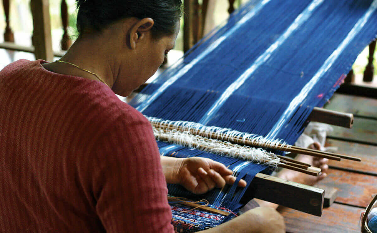 Saeng Sakorn, weaving on a back strap loom.