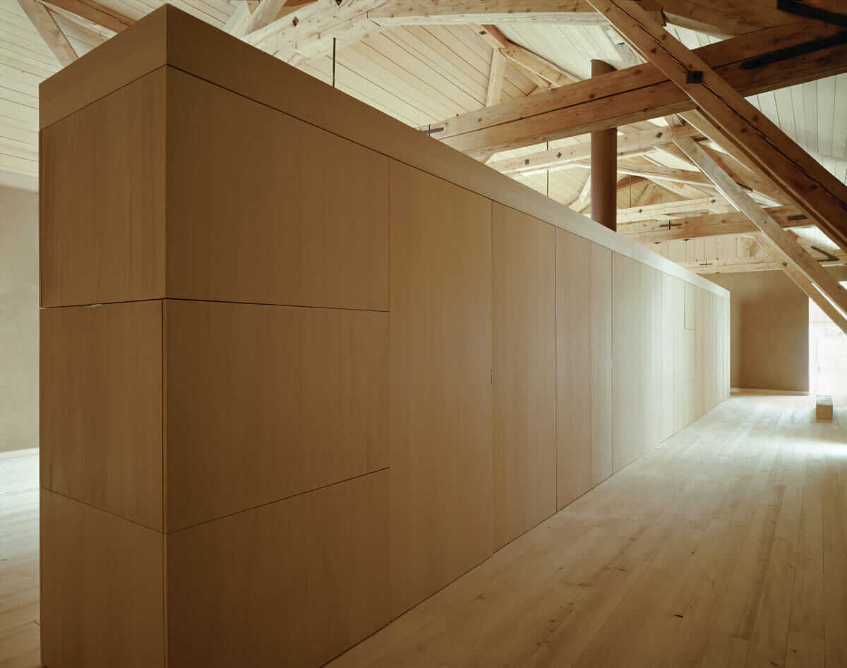 Inside the barn, long cupboards separate public space from private space. 