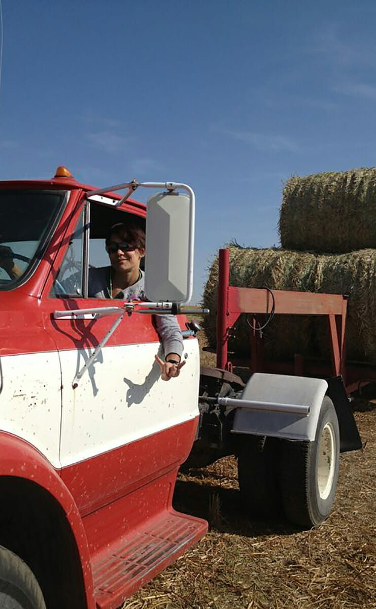 Katie collecting round bales of hay at her farm.