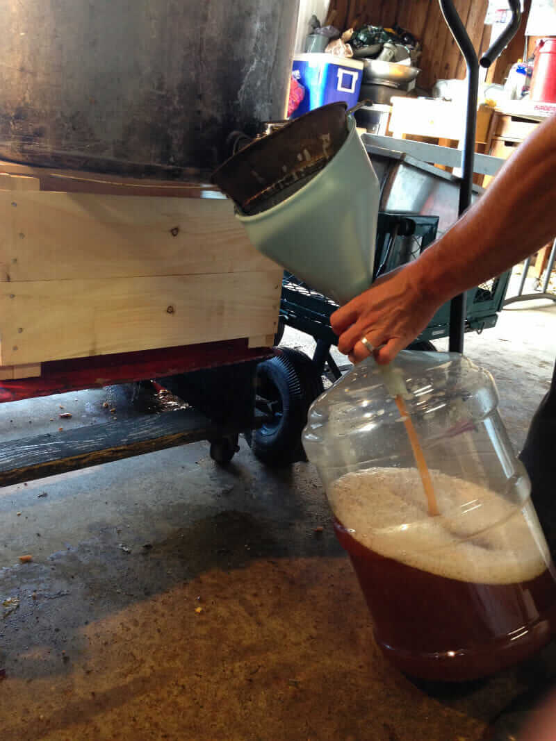 Cider is poured into a jug.