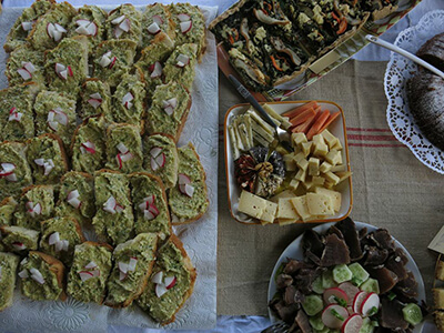 A stack of country bread topped with spring herb puree and radishes joined homemade cheeses, charcuterie, and a mushroom tart.