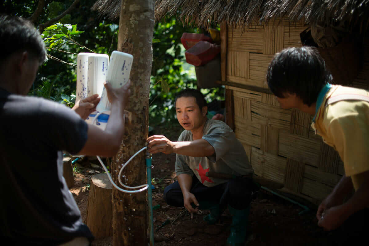 Farm workers navigate a tangle of tubes as they instal a new water filter.