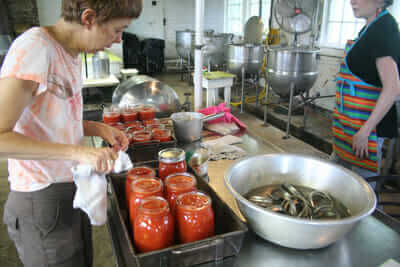 Lise Metzger wipes the rims before putting lids on the jars.