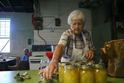 Vera Bowman, who has been using the cannery in Keezletown for decades, puts lids on her jars of zucchini pickles.