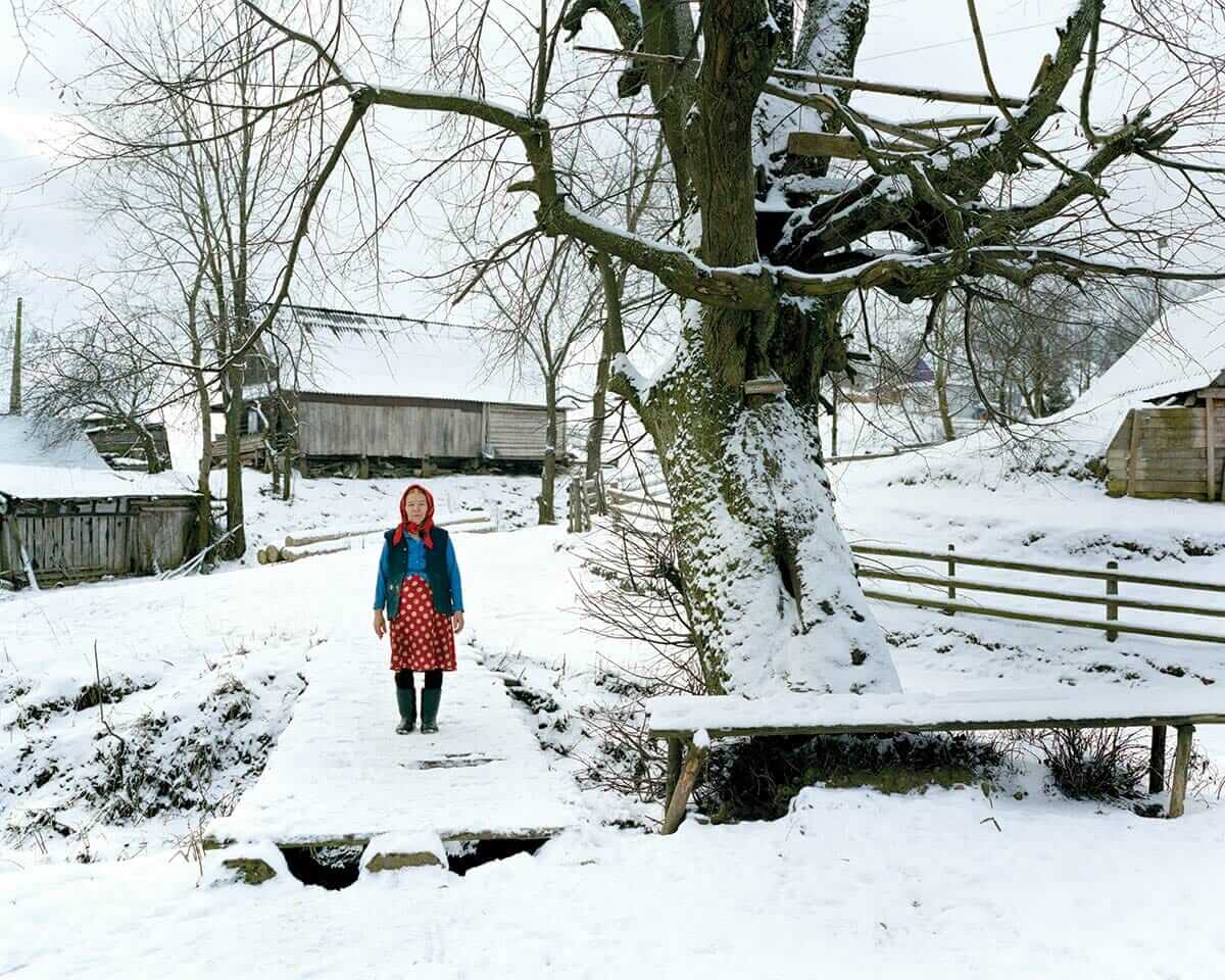 A villager poses for a portrait near her house.