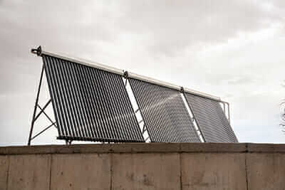 Solar hot water panels mounted on top of a 29-gallon rainwater storage tank.