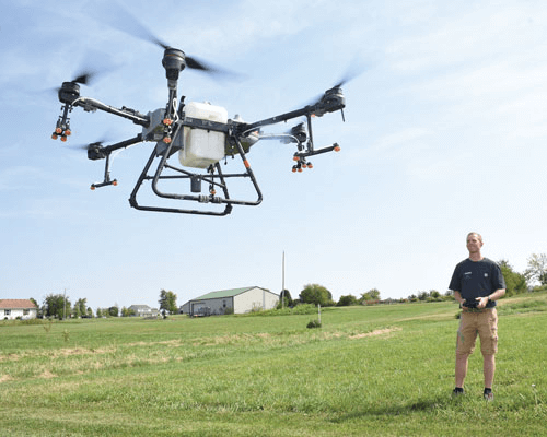 A person flies a drone in a field.