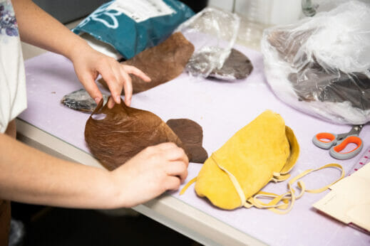 Hands working with kombucha leather.