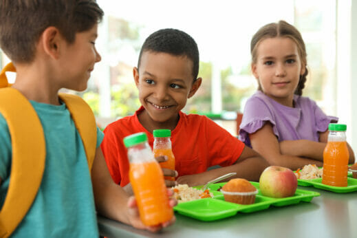 Three children having lunch at school.