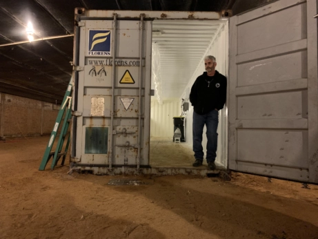 Craig Watts stands in front of a storage container.